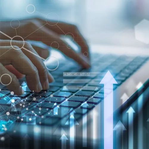 Hands typing on a laptop keyboard with digital arrows and network graphics symbolizing SEO and website growth.