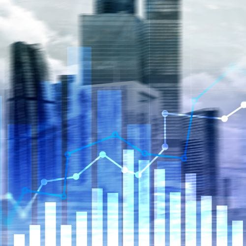 Blue bar and line graphs overlaid on a blurred city skyline, illustrating financial or business data trends.